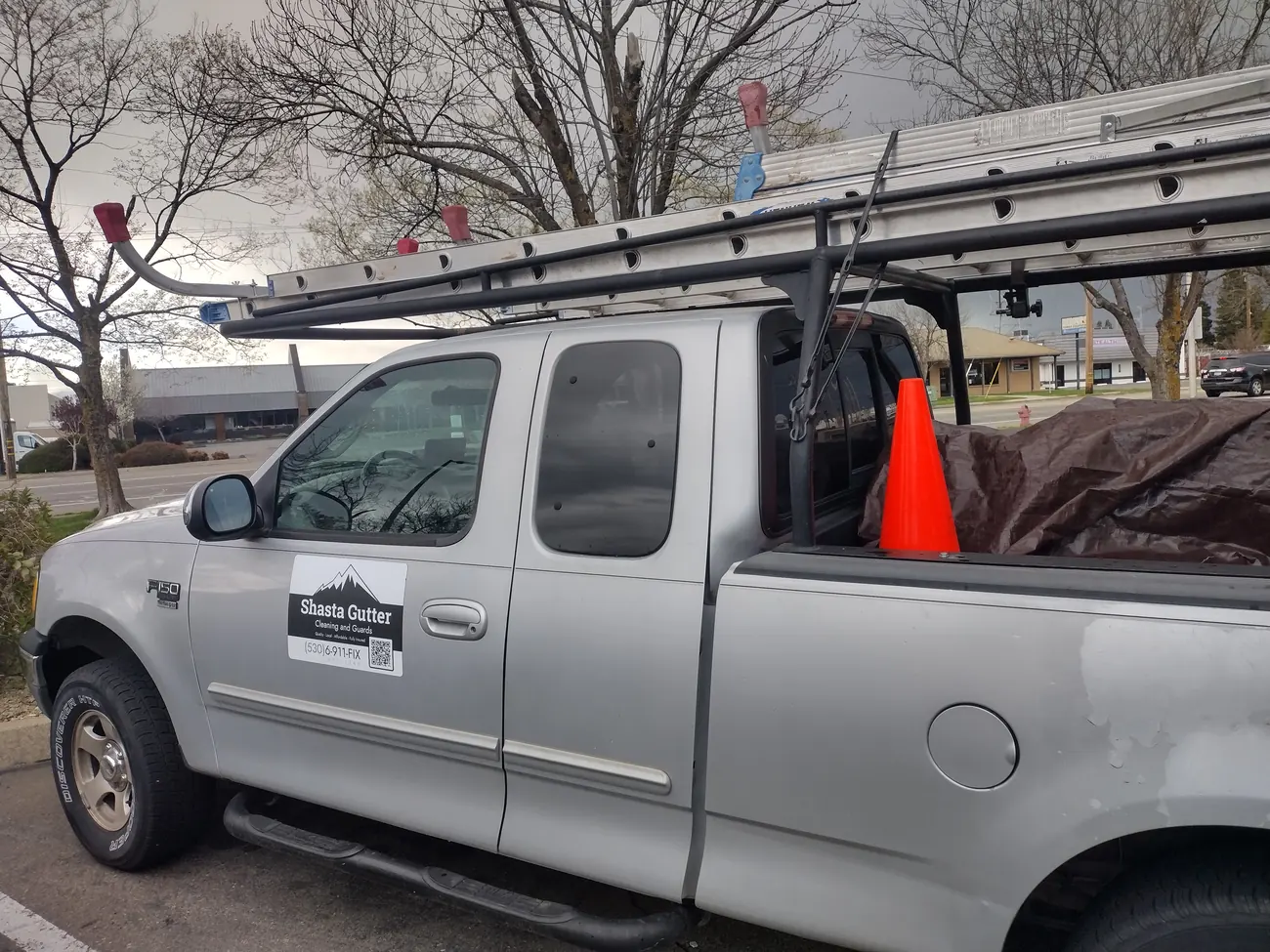 The branded Shasta Gutter Cleaning and Guards work truck loaded with ladders in Redding